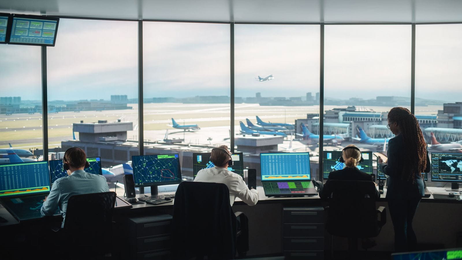 Air traffic controllers monitoring flights in an airport control tower.